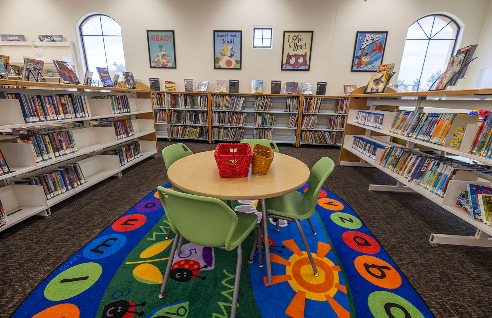 Photo of a kid's activity table in the library with the kids books in the background