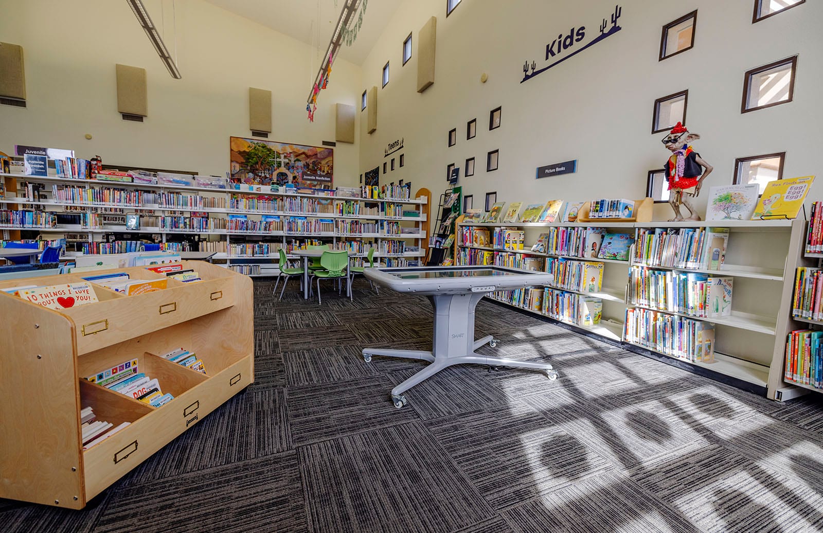 Photo of board books shelf, kids activity table and picture book shelves